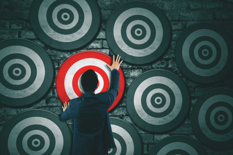 man positioning dartboard among other dartboards